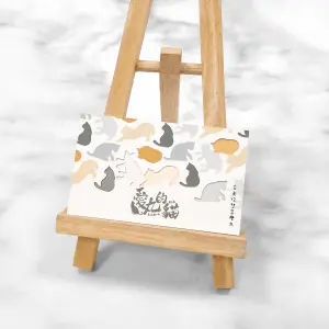 使用如意白卡材質雕刻貓型圖案，底層透出灰、橘、白等多色層次。整體風格溫暖可愛，適合文創或寵物品牌。