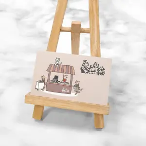 以可愛貓咪攤位插畫為主題，，色調柔和溫暖。雙面霧膜質地細緻，色彩飽和卻不反光，充滿溫馨手繪風格。