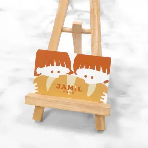 暖橘與米色構成可愛插畫設計，霧面底層柔和細緻，局部上光使圖像人物與品牌文字產生光澤反射，整體溫馨活潑。