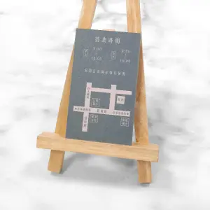 細波紙名片表面具有不規則紋路質感，深灰底色搭配淺藕色圖文，印刷細節清晰，展現沉穩又具設計感的風格。