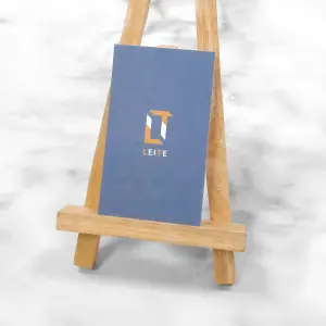 直式深藍底襯托白與仿金logo。萊妮紙的布紋在霧面質感中帶出細緻光影，襯托品牌的高質感定位。